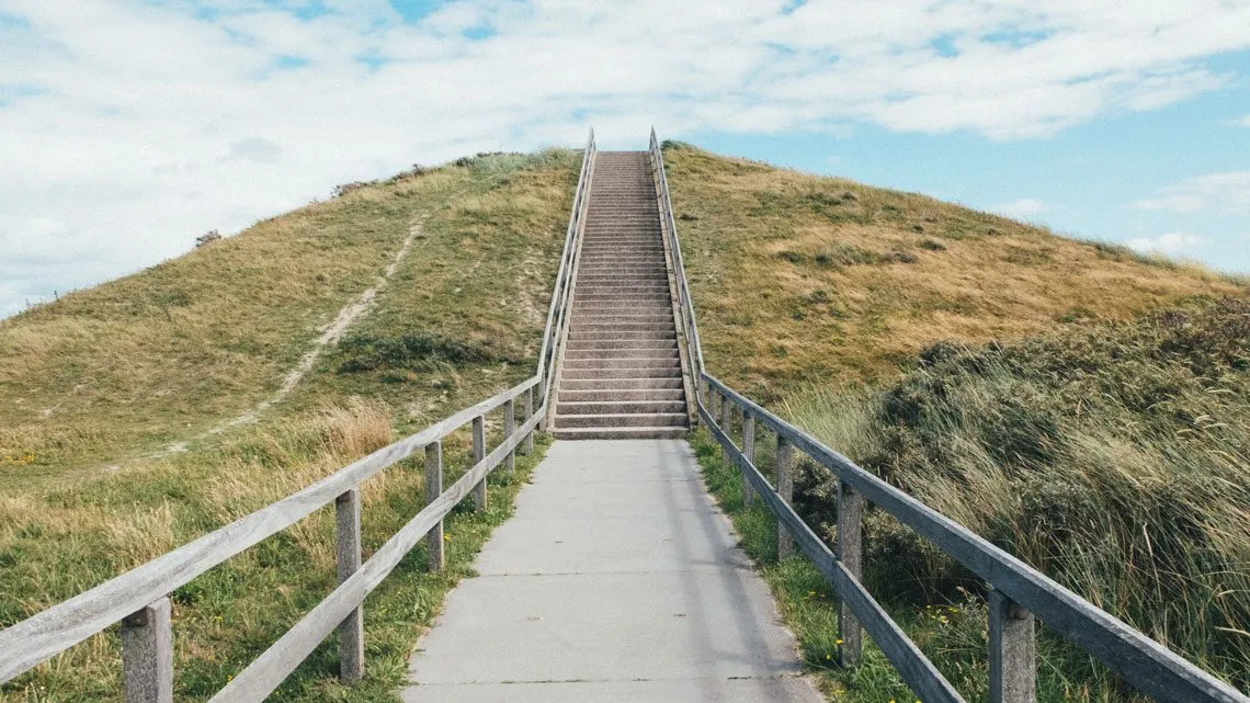 Treppe führt einen begrünten Hügel hinauf
