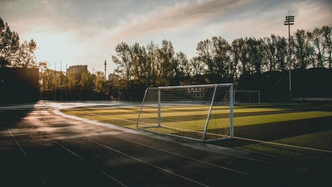 Leeres Fußballtor auf einem Sportplatz in der Abendsonne